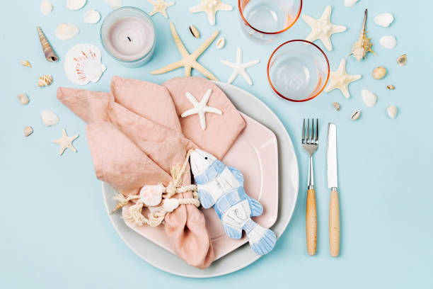 istock Table Setting and sea decorations for serving a festive table. Plates, wine glasses and cutlery on blue background. Summer concept. Flat lay, top view 1153497555
