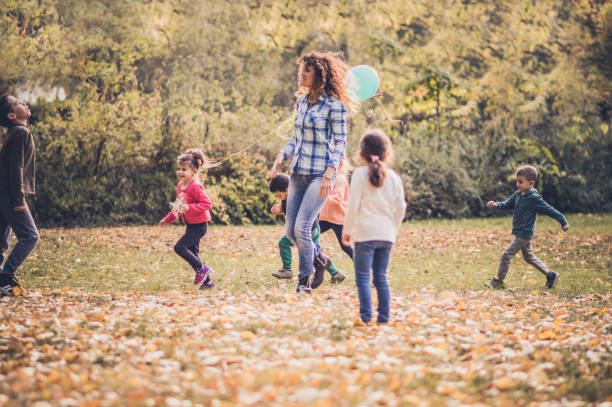istock Group of happy children having fun while running in an autumn park 1153498962