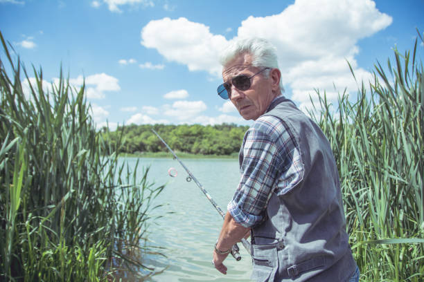 istock Man fishing by a lake 1153502839