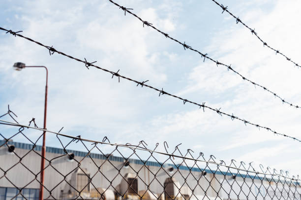 istock Barbed wire fence in front of prison 1153505965