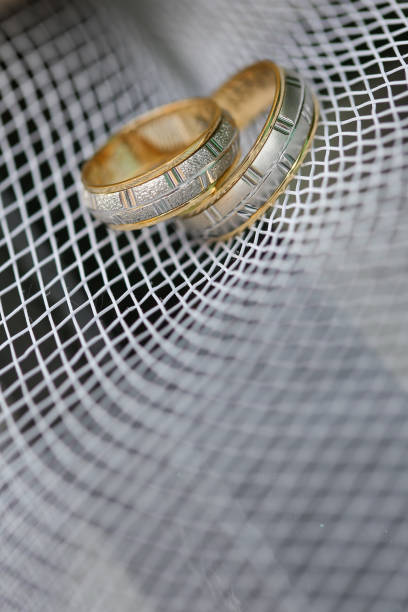 istock Golden wedding rings on the white mesh. 1153505976
