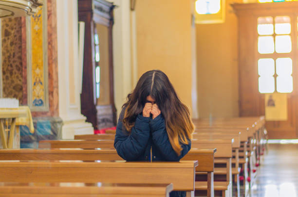 mulher cristã que praying na igreja católica - kneeling praying women begging - fotografias e filmes do acervo