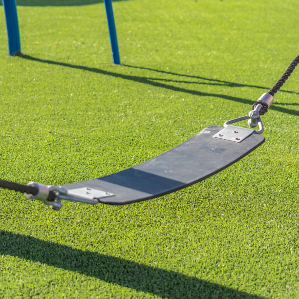 istock Square Play area with a seat supported by ropes that are connected to red poles 1153512583