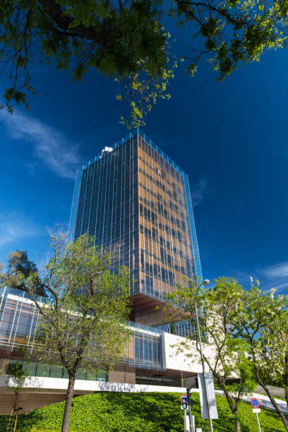 Modern office building (Edificio Castelar) along the Paseo de la Castellana street in Madrid against a clear blue sky.