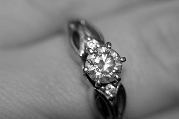 istock Diamond engagement ring on finger in black and white. 1153514545