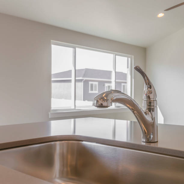 istock Square Shiny kitchen counter top with sink and faucet inside a new home 1153515754
