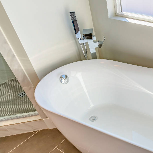 istock Square frame Interior of a bathroom with a smooth and glossy bathtub in th corner 1153515798