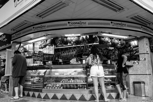 Rio de Janeiro, Brazil - August 24, 2018: Two women buy juice at a street stall in Copacabana. Image process contain exessive noise or grain. Black and white image