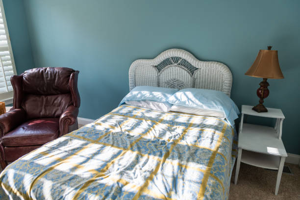 nowe czyste łóżko ze stołem i lampą vintage plaża temat niebieski zielone poduszki w sypialni w domu lub mieszkaniu przez czerwoną skórzaną kanapę - bed and breakfast bed green indoors zdjęcia i obrazy z banku zdjęć