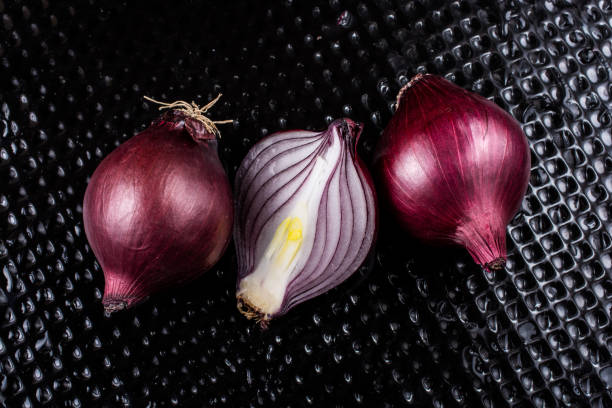 istock Red onion bulb cut in half on certain  background 1153517261
