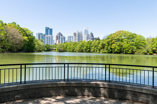 Atlanta, USA Cityscape skyline view in Piedmont Park in Georgia downtown green trees urban city skyscrapers with railing in summer