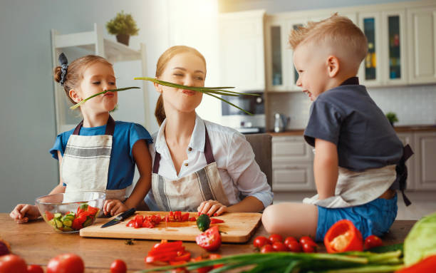 istock mother with children preparing vegetable salad 1153520164