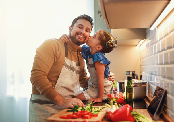 szczęśliwy ojciec rodziny z córką dziecka przygotowuje sałatkę warzywną - domestic kitchen people fun lifestyles zdjęcia i obrazy z banku zdjęć