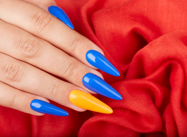 Mano Con Uñas Artificiales Cuidadas De Color Con Esmalte De Uñas Azul Y  Naranja Foto de stock y más banco de imágenes de Adulto - iStock