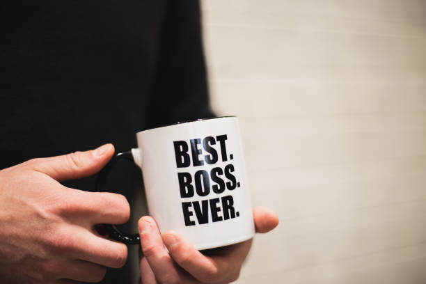 istock A man holding a coffee mug with best boss ever printed on it. 1153522157