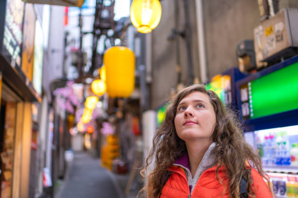 東京, 日本メモリレーンは、黄色の紙のランプを小便します街灯のボケ味と若い外国人女性の新宿エリア - 観光客 ストックフォトと画像