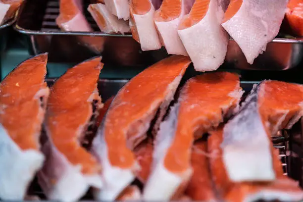 Tokyo, Japan closeup of raw salmon in street market in Tsukiji near Ginza with red pink wild flesh and skin on display