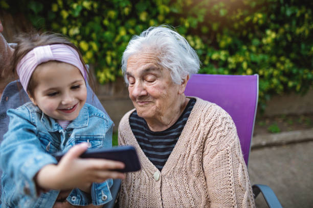 little four year old girl explaining grandma new technology - 80 year old imagens e fotografias de stock