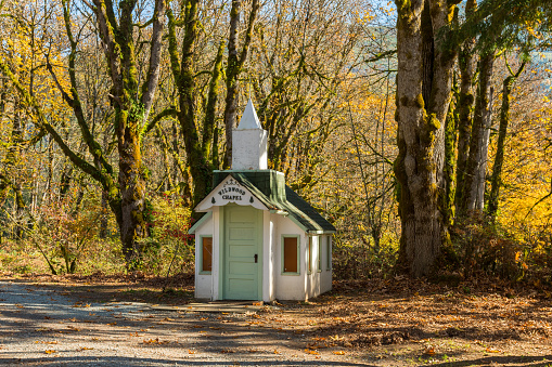 Tiny Upriver Chapel next to the Skagit River and a lush forest near Rockport, Washington, USA
