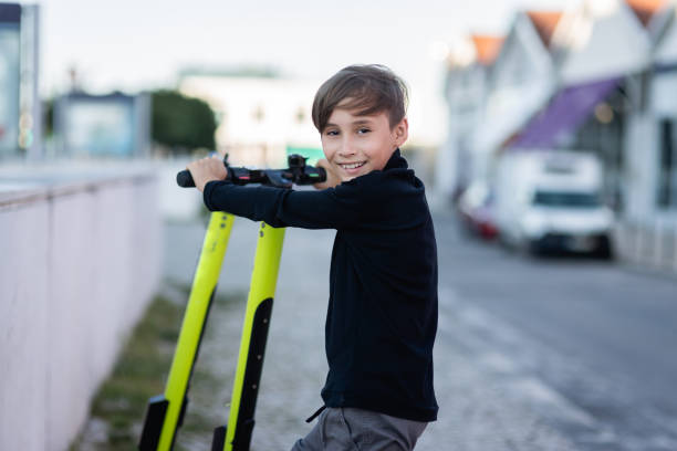istock Boy using a mobile phone for unlocking an electric scooter by app 1153528633