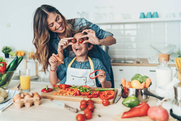 istock Mother and daughter making salad and having fun 1153535348