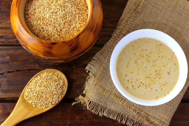 tahini in ceramic bowl on rustic wooden table- cream or paste made from sesame seeds (sesame) widely used in middle eastern cuisine - sesame seed spoon scoop imagens e fotografias de stock