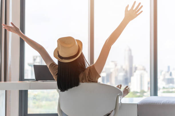 Life balance and summer holiday vacation concept with happy woman taking a break, celebrating successful work done, casually resting in luxury city hotel workplace with computer pc laptop on desk el equilibrio de vida y el concepto de vacaciones de verano con la mujer feliz tomando un descanso, celebrando el trabajo exitoso hecho, casualmente descansando en el lugar de trabajo de lujo de la ciudad hotel con ordenador portátil pc en el escritorio