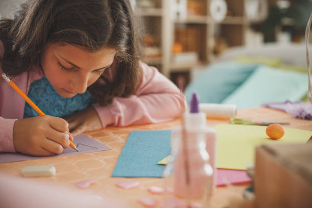 istock Girl drawing on colored paper 1153537060
