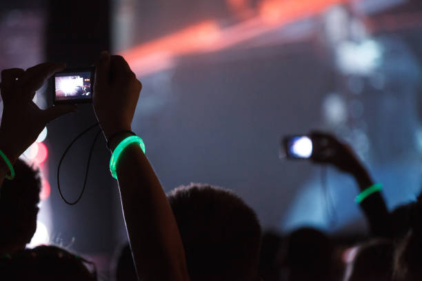 los fans graban videos con teléfonos celulares durante el concierto - applauding clapping wristband crowd fotografías e imágenes de stock