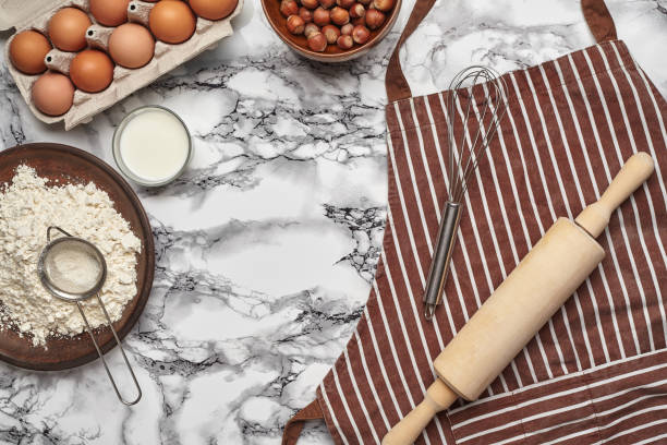 istock Close-up shot. Top view of a baking ingredients and kitchenware on the marble table background. 1153539690