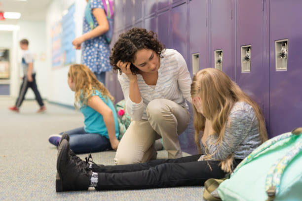 istock A teacher consoling a left-out student at an elementary school 1153541388