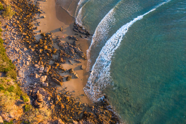小さなビーチと穏やかな青い波を持つ海辺の村の美しい空中画像 - beach sunset sand wood ストックフォトと画像