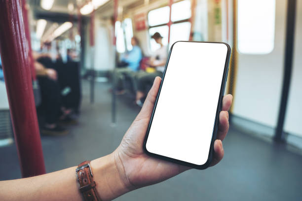 istock woman's hands holding black mobile phone with blank screen in subway 1153555828