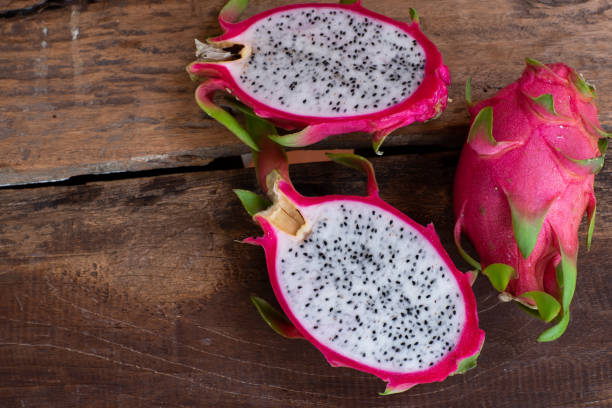 istock Organic white fresh dragon fruit cut into half on wooden chopping board, copy space 1153565274