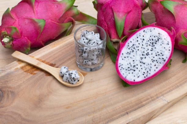 istock Organic white fresh dragon fruit cut into half on wooden chopping board, copy space 1153565277