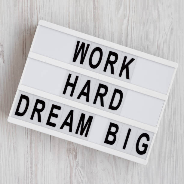istock 'Work hard dream big' words on a modern board on a white wooden background, top view. Flat lay, overhead, from above. 1153568197