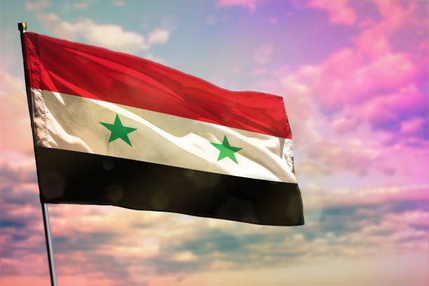 istock Fluttering Syrian Arab Republic flag on colorful cloudy sky background. Prosperity concept. 1153570462