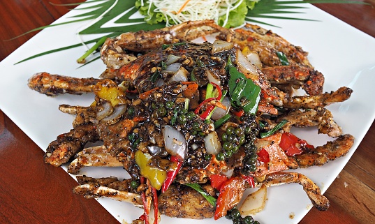 Stir fried spicy crab with black pepper sauce on white plate. Thai seafood background.