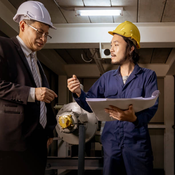 istock Asian engineers look at blueprint. 1153574794