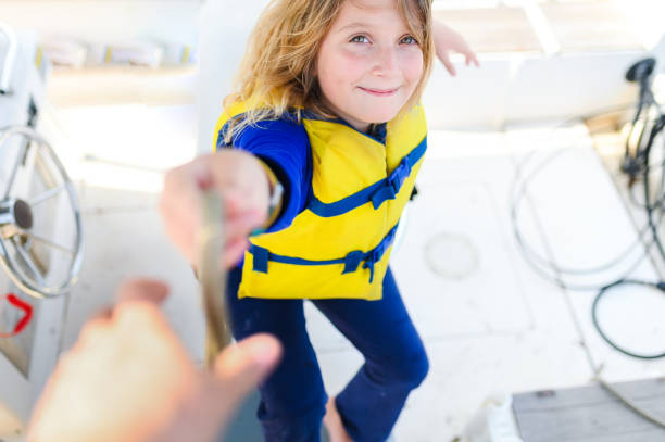 istock Boating child handing a dock line over wearing a colorful life jacket 1153574830