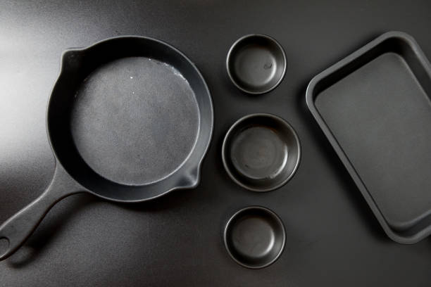 istock Set of empty frying pan and bowl on black table. 1153576620