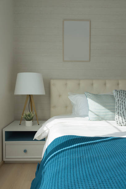 istock White lamp next to bed with navy blue bedding. 1153576630
