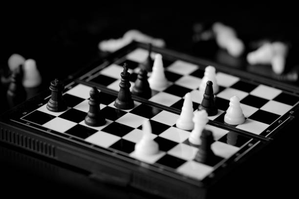 istock Travel Chess on a dark background close up. Black and white 1153577449