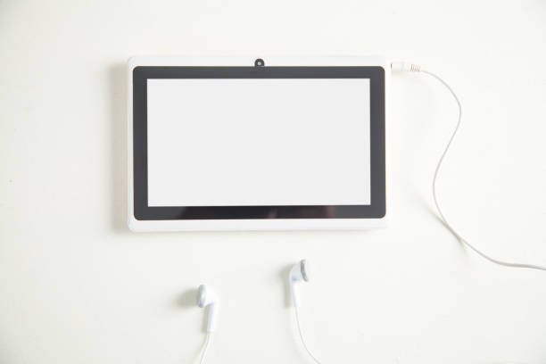 istock Tablet with a earphones on white desk. 1153581472