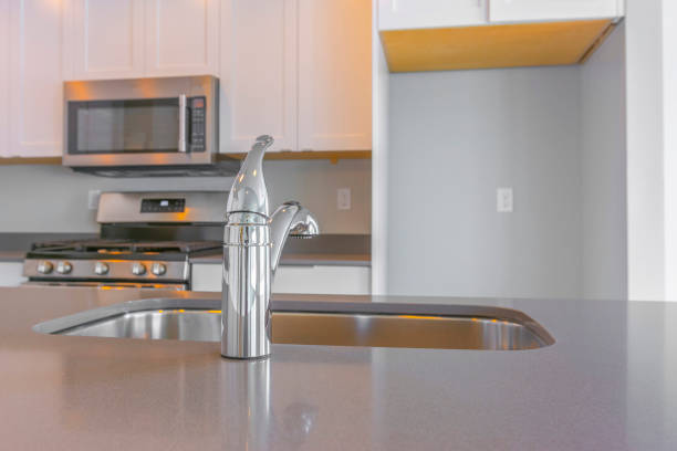 istock Modern kitchen interior with close up on the shiny faucet and sink 1153582703