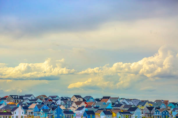 istock Panoramic view of houses under vast sky filled with illuminated puffy clouds 1153590966