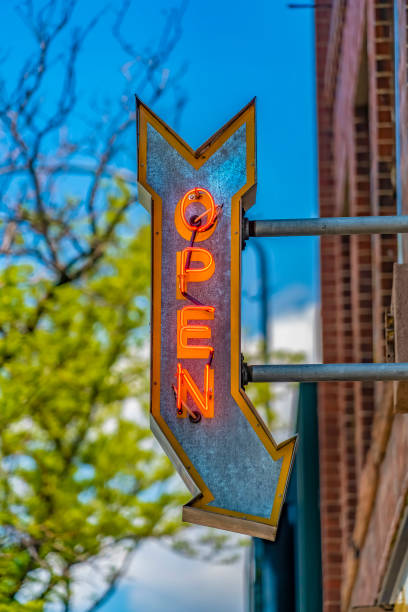 istock Red brick building with an Open arrow sign viewed on a sunny day 1153591030