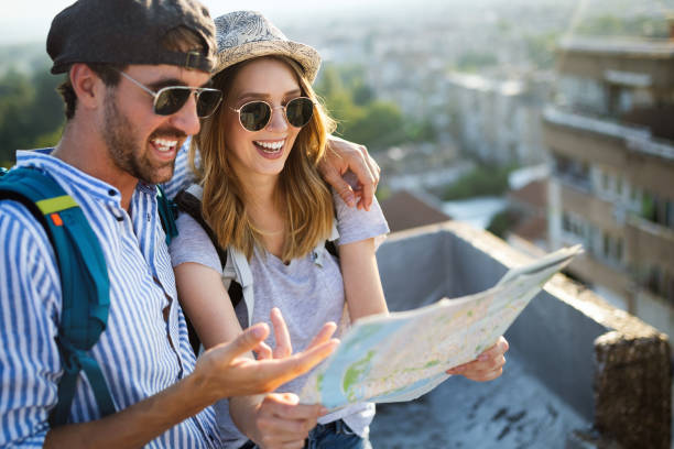 istock Happy couple on vacation sightseeing city with map 1153591795