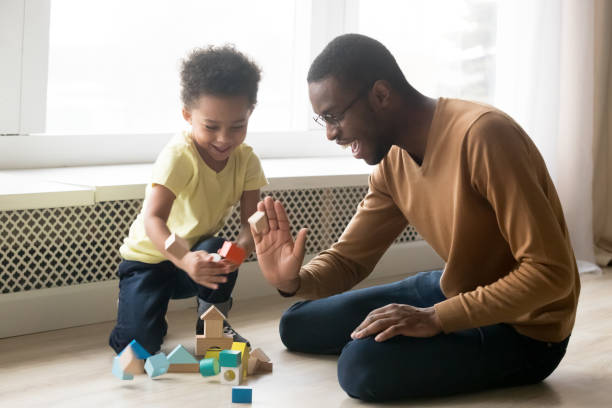 istock Cheerful dad and son play together with toy blocks 1153592546