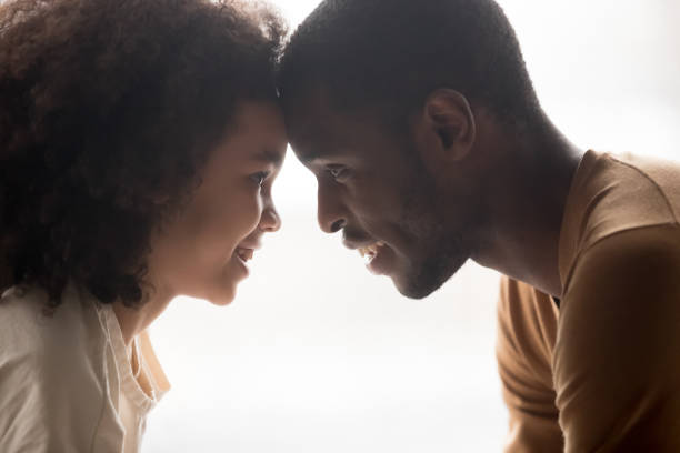 istock Close up profile faces african smiling father and daughter 1153592586